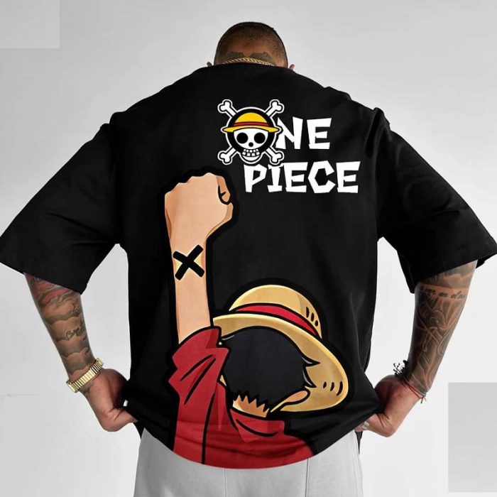 Person wearing a black "One Piece" T-shirt featuring a character with a straw hat and raised fist.