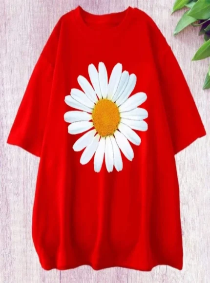 Red t-shirt with a large white daisy print on the front, lying flat on a textured surface.