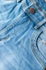 Close-up of a denim jacket's front with button and seam details.