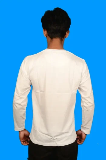 A person stands facing away, wearing a plain white long-sleeve shirt against a solid blue background. The scene is simple, focusing on the clothing.